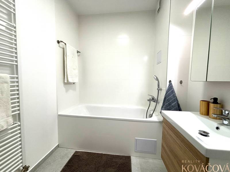 Bathroom in a 3-room apartment with a bathtub and a sink, tiles on the walls.