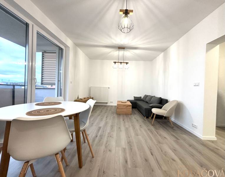 Living room in a 3-room apartment with a sofa, table, and wooden decor flooring.