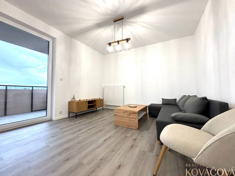 Living room with a sofa, armchair, table, and wooden decor flooring in a 3-room apartment.