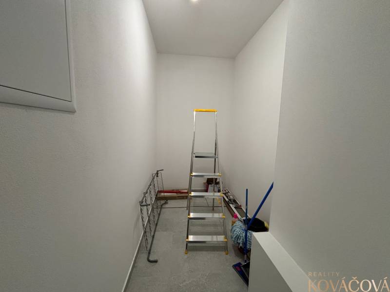 Storage space with a ladder, broom, and drying rack in a 3-room apartment.