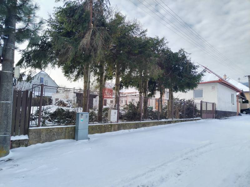 A family house on Hájska Street in Martin, a snowy exterior with trees and a fence.