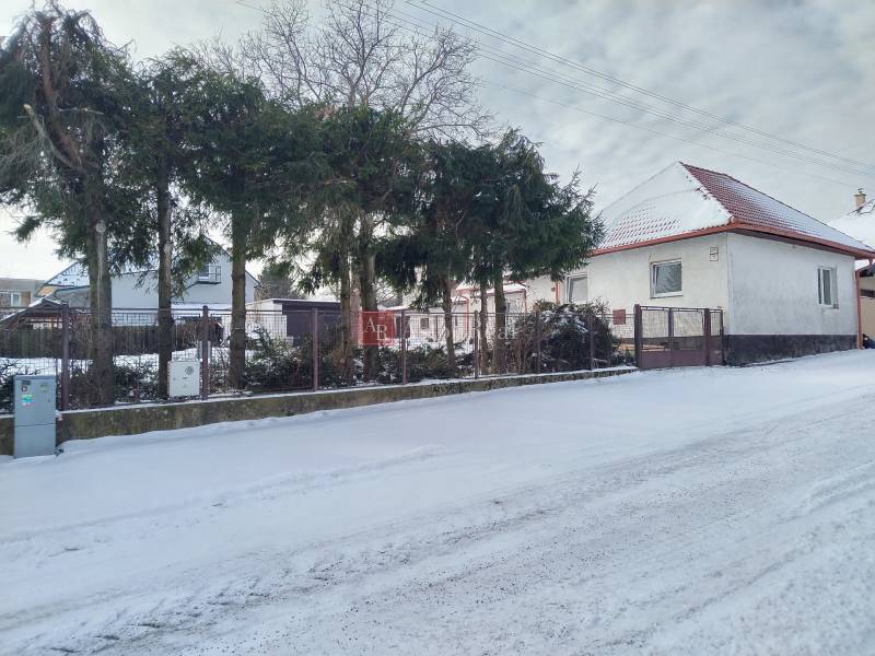 A family house on Hájska Street in Martin with a snow cover and trees in the garden.