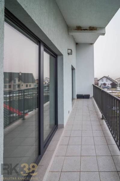 The balcony of a family house on Krátka Street in Spišské Bystré with tiles and glass railing.
