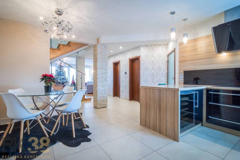 Interior of a family house with a dining table, staircase, and Christmas tree.