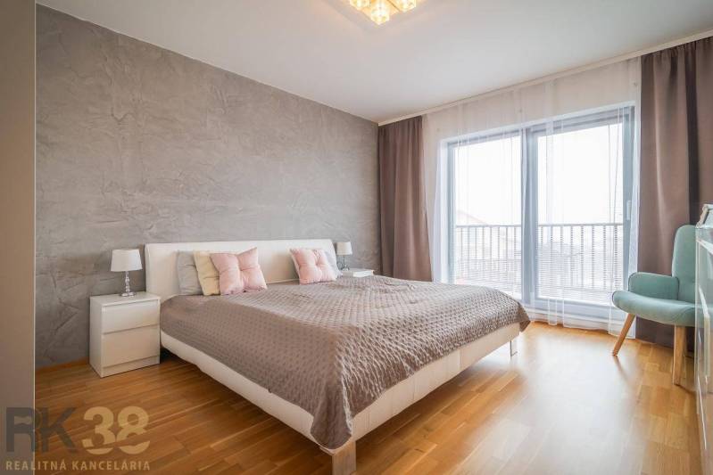Bedroom in a family house with a bed, nightstands, and a floor with a wood decor.