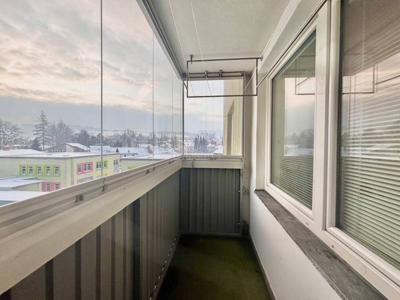 A glazed balcony with a view of the snowy panorama of the town of Turzovka on Centrum Street.