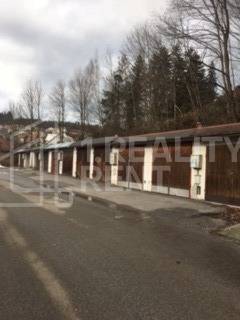 Row of garages on Centrum Street in Turzovka with the designation of a verified member of the real estate agency.