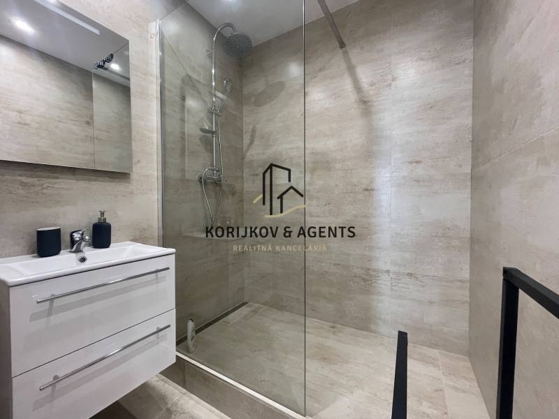 Bathroom in a 3-room apartment with a shower and storage space under the sink.