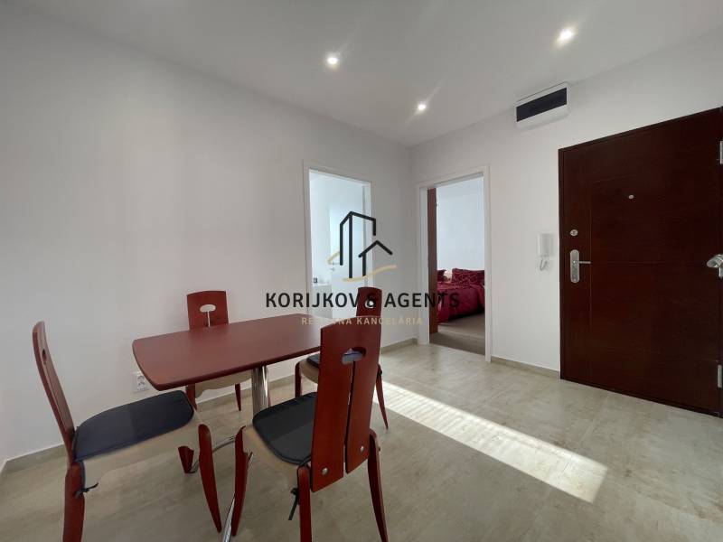 Dining table and chairs in the hallway of a 3-room apartment with tiles.