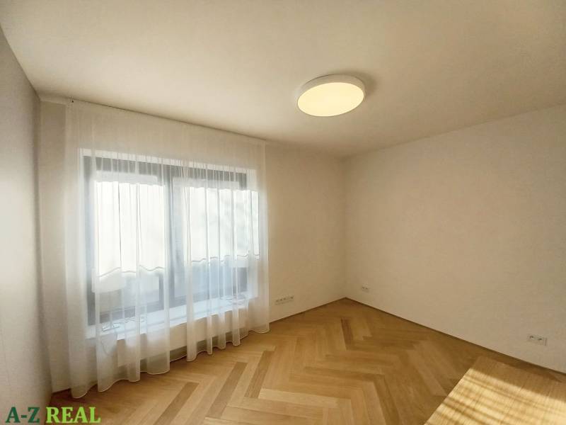 A room with a ceiling light and a floor with a wood decor in a 4-room apartment.