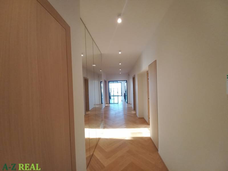 Hallway in a 4-room apartment with a wooden decor floor and a mirror.