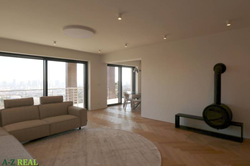 Living room with a sofa, fireplace, and wooden decor flooring in a 4-room apartment.