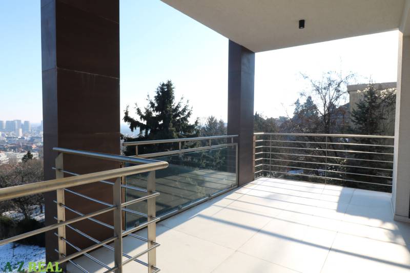 A balcony with a railing and a view of the city from a 4-room apartment in Bratislava.