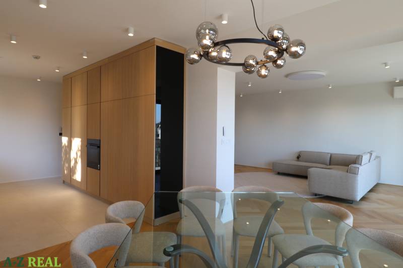 Living room with a dining table, sofa, and light fixture in a 4-room apartment, floor with wood decor.