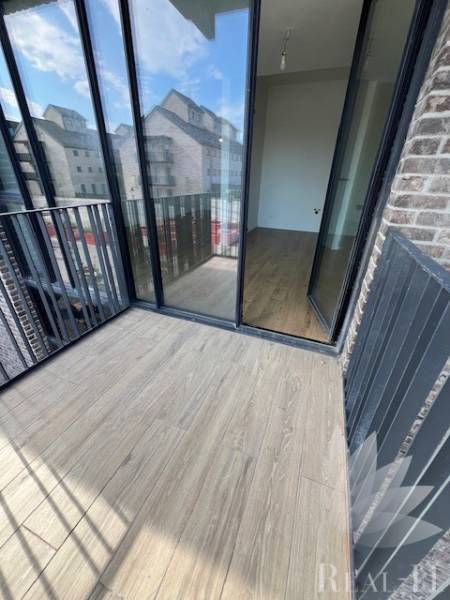 A balcony of a 2-room apartment with glazing and a floor with a wooden decor.