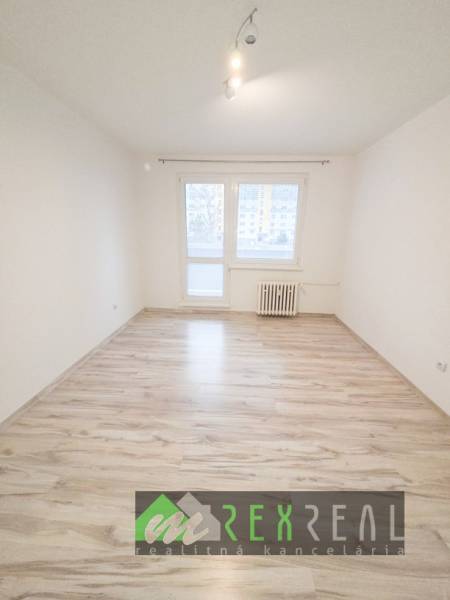 A bright room with a wood-patterned floor in a 3-room apartment.