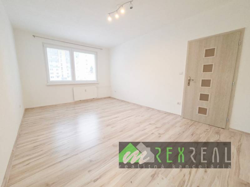 A room in a 3-room apartment with a wood-patterned floor and a window.