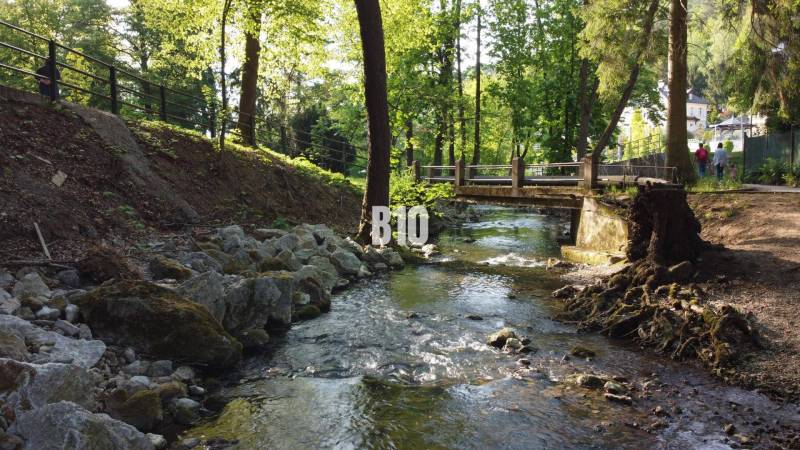 A stream and a bridge surrounded by greenery in Trenčianske Teplice suitable for residential land.