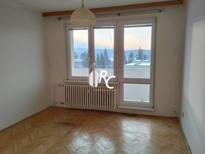 A room with a bright interior and a wooden decor floor in a 2-room apartment.