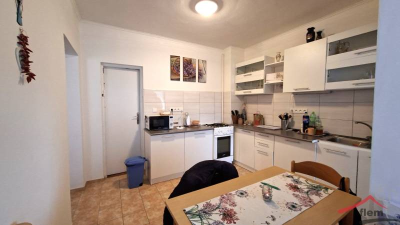 A kitchen in a family house with white furniture, a stove, and a dining table.