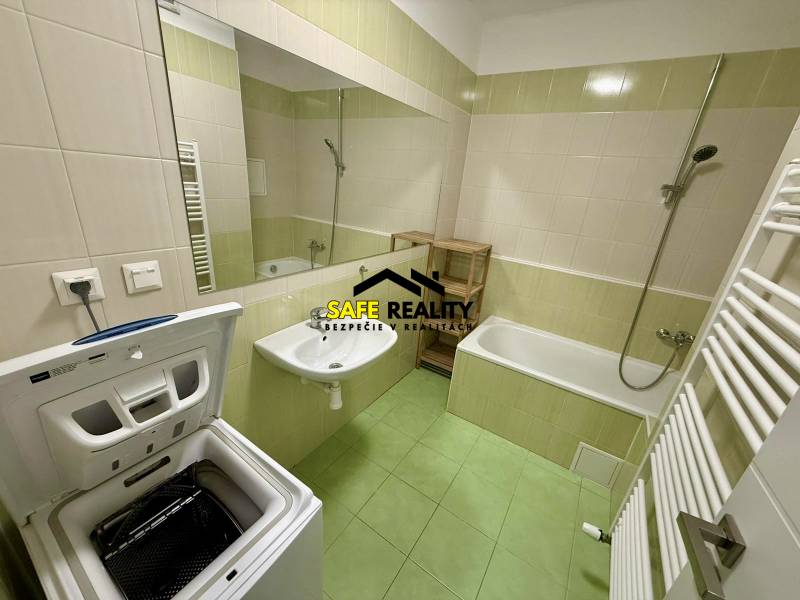 Bathroom in a 2-room apartment with a bathtub, sink, and top-loading washing machine.