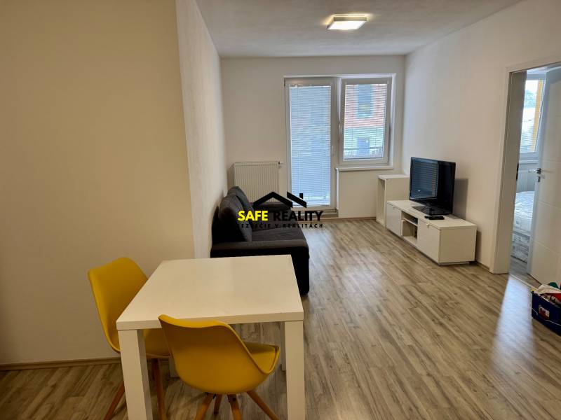 Living room of a 2-room apartment with a wooden decor floor and bright seating.