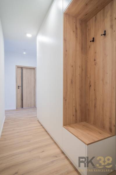 A hallway with built-in furniture in a 2-room apartment, light wooden floors, white walls.