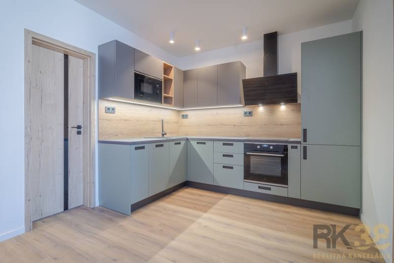 A kitchen in a 2-room apartment with wooden flooring and light gray cabinets.