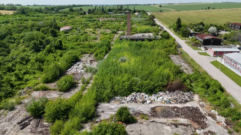 Overgrown commercial plots in Ivanka pri Nitre with extensive vegetation and a road.