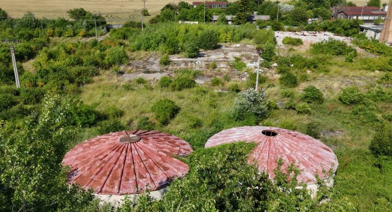 Commercial plots in Ivanka pri Nitre with circular roofs, surrounded by lush greenery.