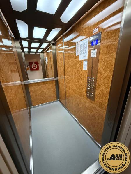 An elevator with a wooden decor and modern lighting can be found in a 3-room apartment.