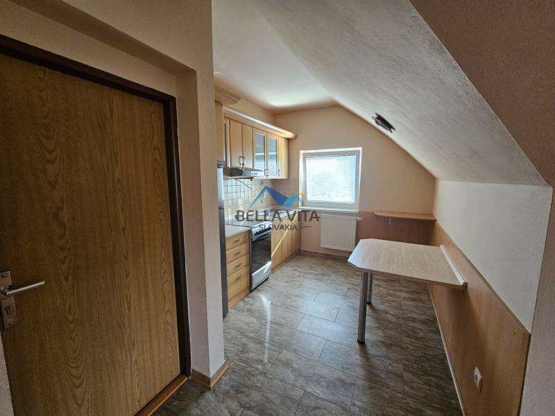 A kitchen in a building with a wood-patterned floor and basic equipment.