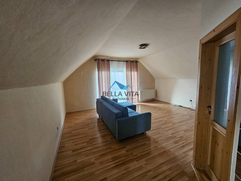 Interior with wood-patterned flooring, a sofa, and curtains in a building.