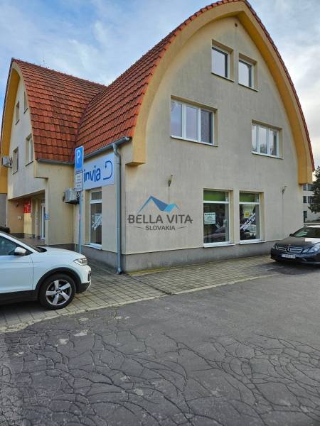 The building on Children's Square in Galanta with an arched roof and parking spaces.