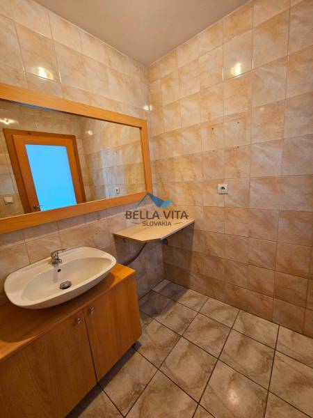 Bathroom with ceramic tiles, a sink, and a mirror in the building.