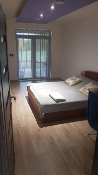 A bedroom in a family house with a bed and a floor with a wooden decor.