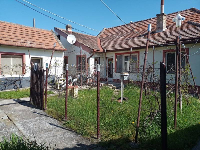 A family house in Nové Zámky with a small garden and a satellite dish on the roof.