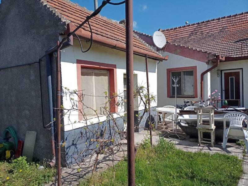 A family house in Nové Zámky with garden furniture, a satellite dish, and a grassy yard.