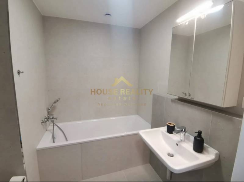 Bathroom with a bathtub and a sink in a studio apartment.