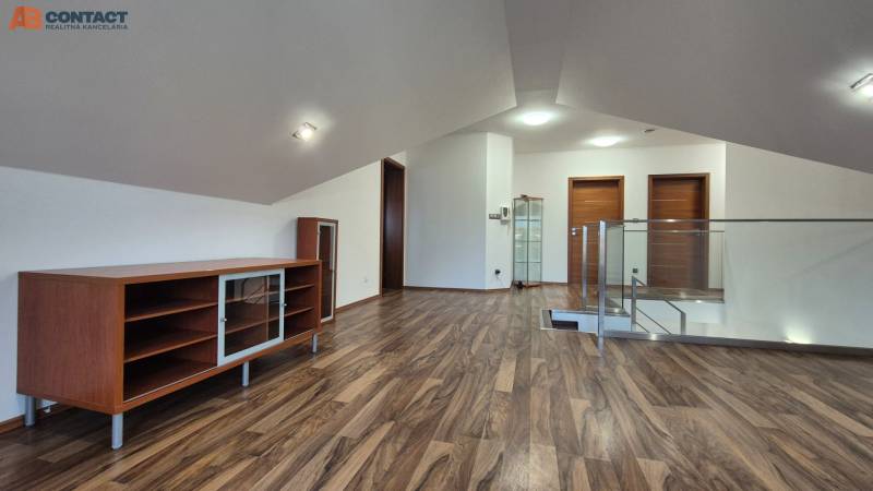 Attic space in a family house with a floor featuring a wood decor and built-in cabinets.