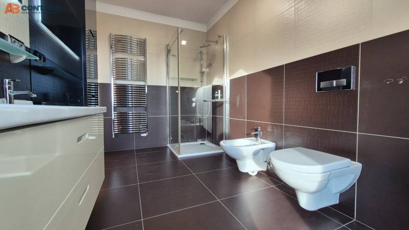 A bathroom in a family house with a modern shower, bidet, and ladder radiator.