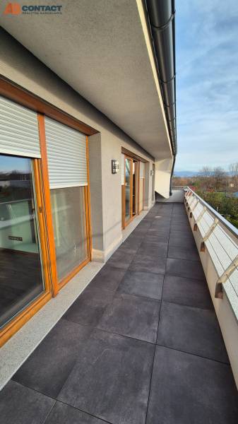 The balcony of a family house on Veterná in Krakovany with glass railings and French windows.