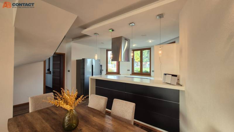 A kitchen with a dining table and a wooden decor floor in a family house.