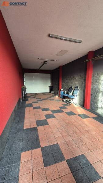 A garage in a family house with tiles and red walls, with office chairs.