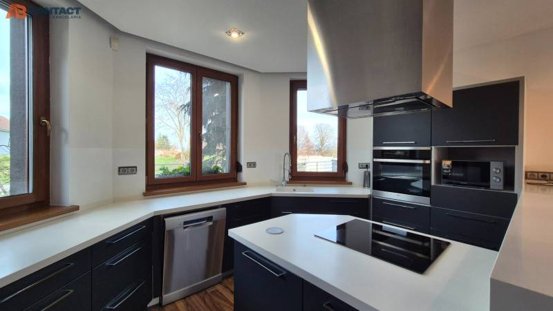 A kitchen in a family house with a white countertop, black cabinets, and appliances.