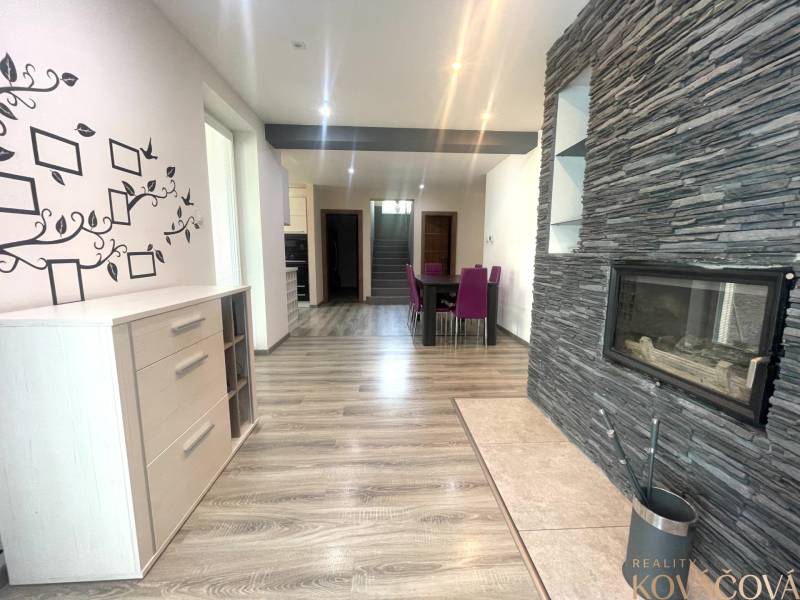 Interior of a family house with a fireplace, wood-patterned flooring, and wall decoration.