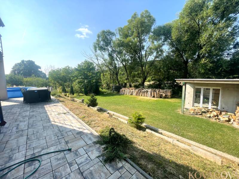 Terrace of a family house in Melčice-Lieskové with a garden, swimming pool, and gazebo.