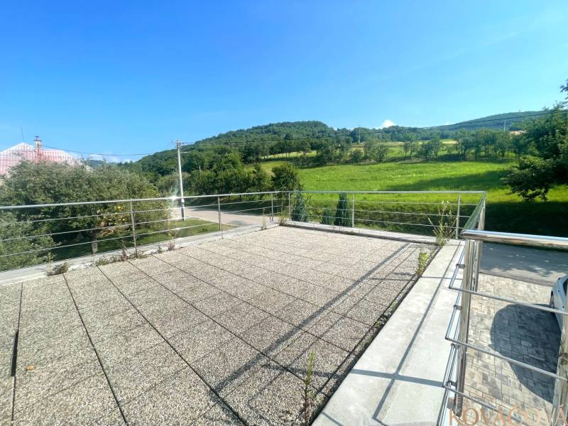 The terrace of a family house in Melčice-Lieskové with a view of the surrounding green landscape.