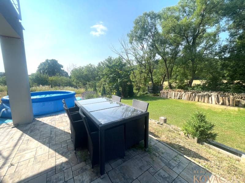 The terrace of a family house in Melčice-Lieskové with a view of the garden and an inflatable pool.