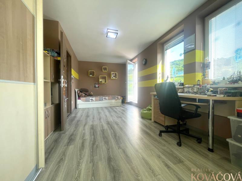 A spacious room in a family house with a wooden decor floor and a work desk.